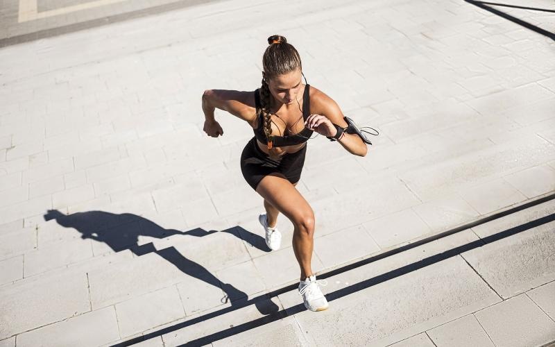 woman exercises running outside up stairs